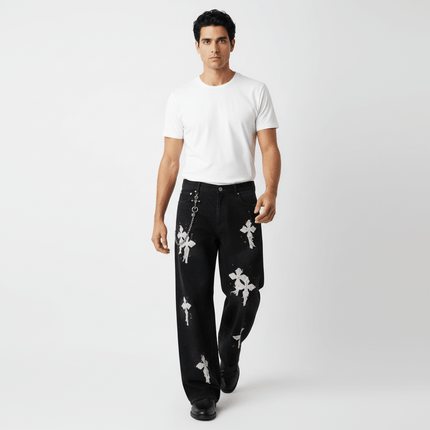 Fashion model wearing Straight Leg Patchwork Denim Jeans featuring cross patch embroidery and color splatter detailing.