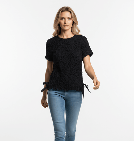 Model wearing a Texture Knitted Bow Round Neck Top in black, featuring a textured knit and bow detail.