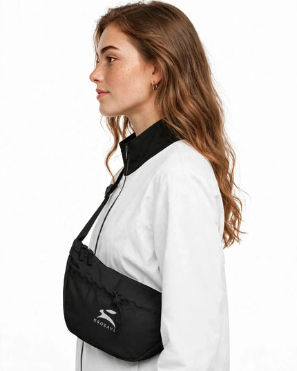Black 12 L day bag worn crossbody on the adjustable strap