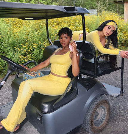 Pleated Vest Two-Piece Set – Loose Fit worn by two women in yellow on a golf cart surrounded by flowers.